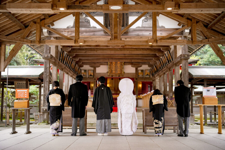宗像大社の神前にて、新郎新婦と両家の家族が一礼を捧げる神前式の様子