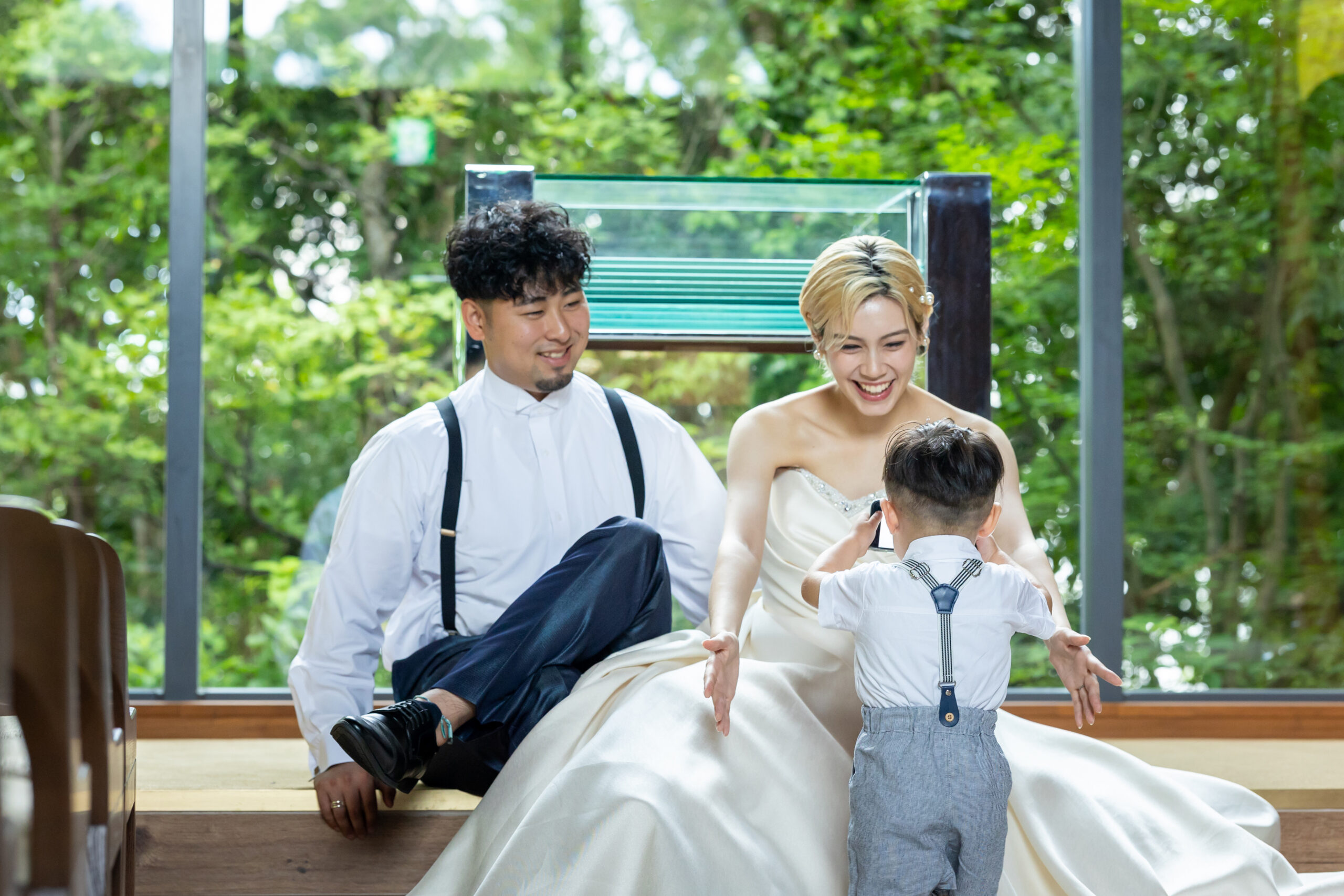 高宮庭園茶寮のチャペル『ミュージックホール』で、新郎新婦が子どもと一緒に微笑むファミリーフォトウェディング