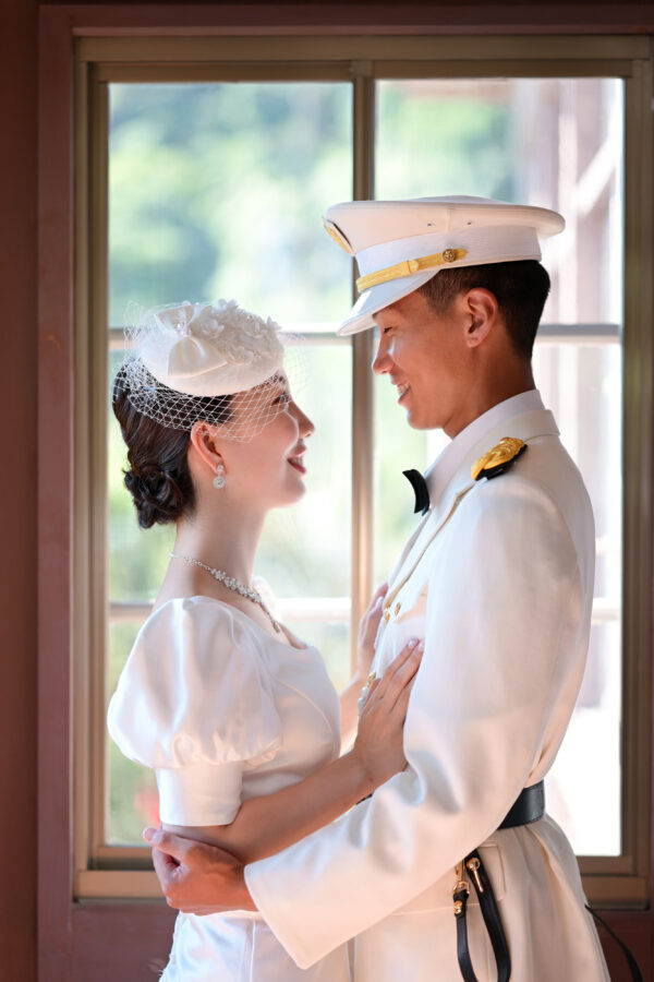 鹿児島異人館の窓辺で抱き合う新郎新婦|自然光が包むロマンチックなウェディングフォト