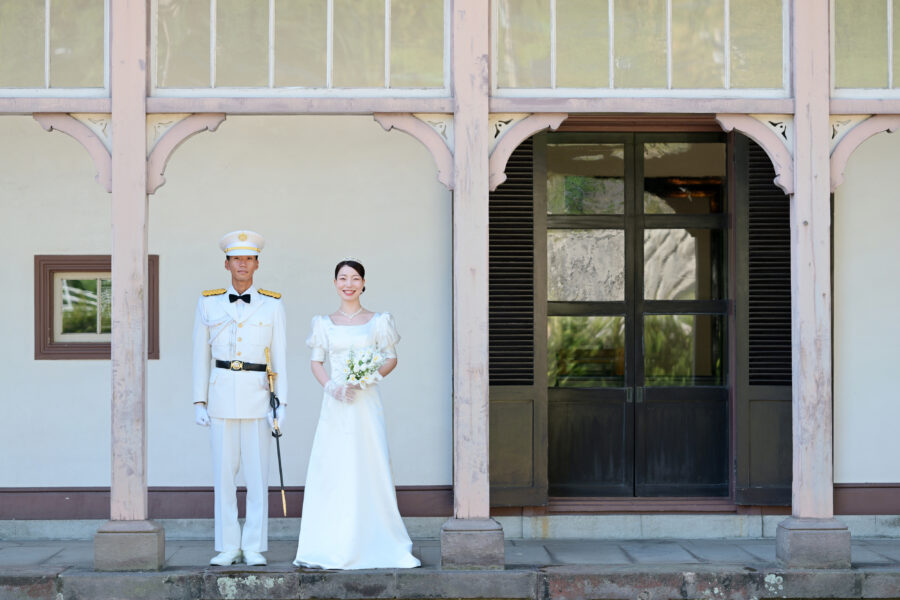 鹿児島異人館の外観前に立つ新郎新婦|白い軍装とクラシカルな建築が調和する前撮り