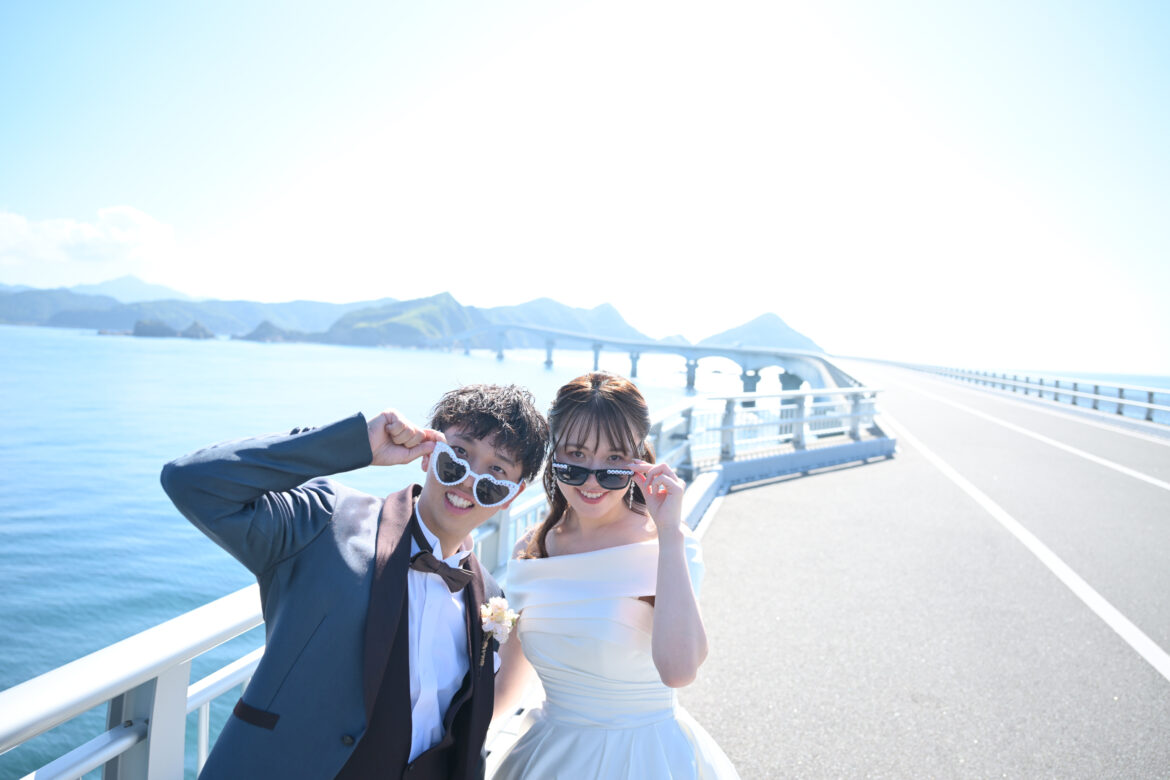甑島・甑大橋でサングラスをかけて笑顔を見せる新郎新婦の前撮り