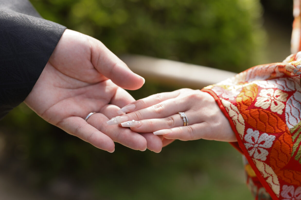 福岡の大濠公園日本庭園で和装姿の新郎新婦が手を重ね結婚指輪を見せる前撮り写真